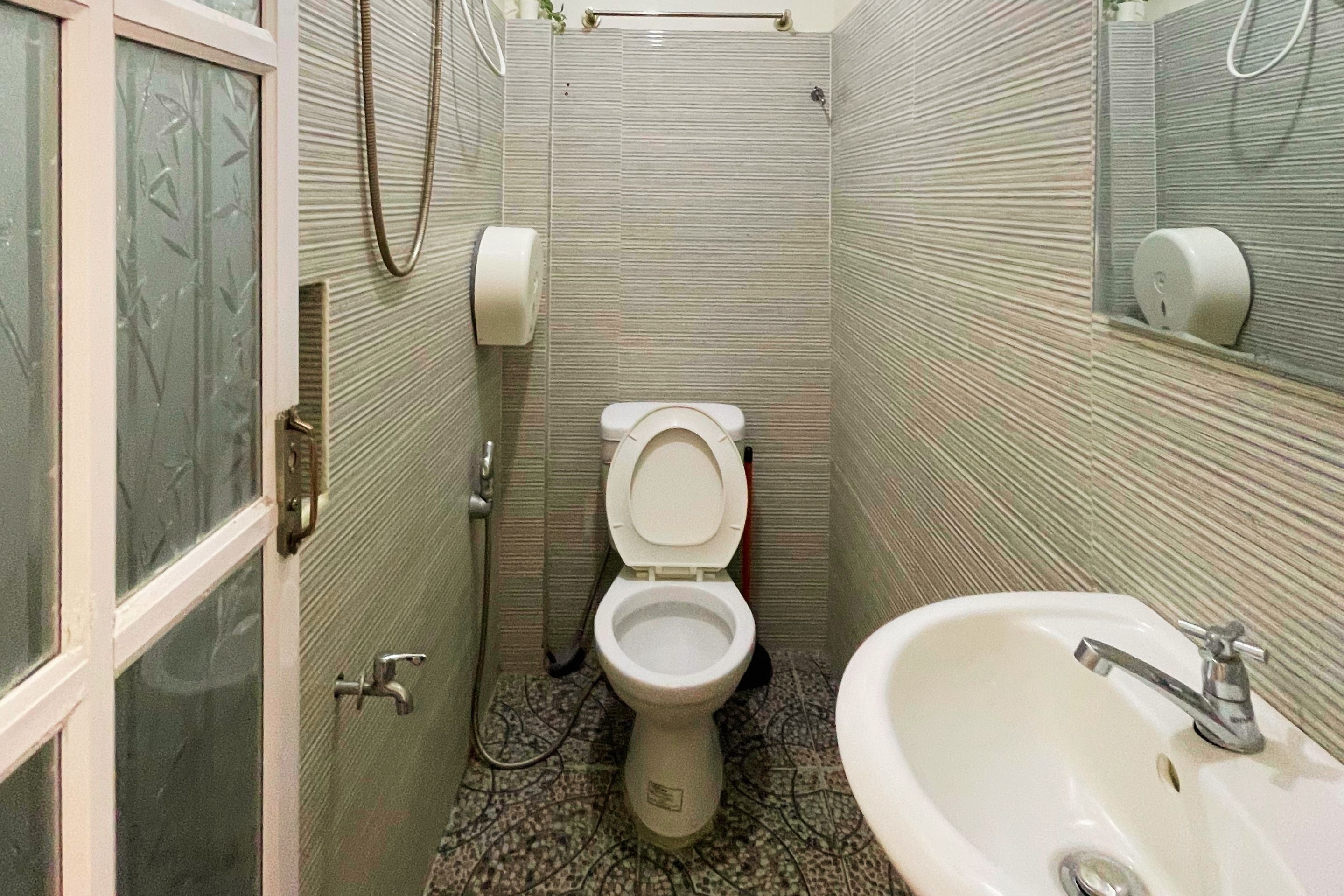 A small bathroom with a toilet, sink, and a shower area.