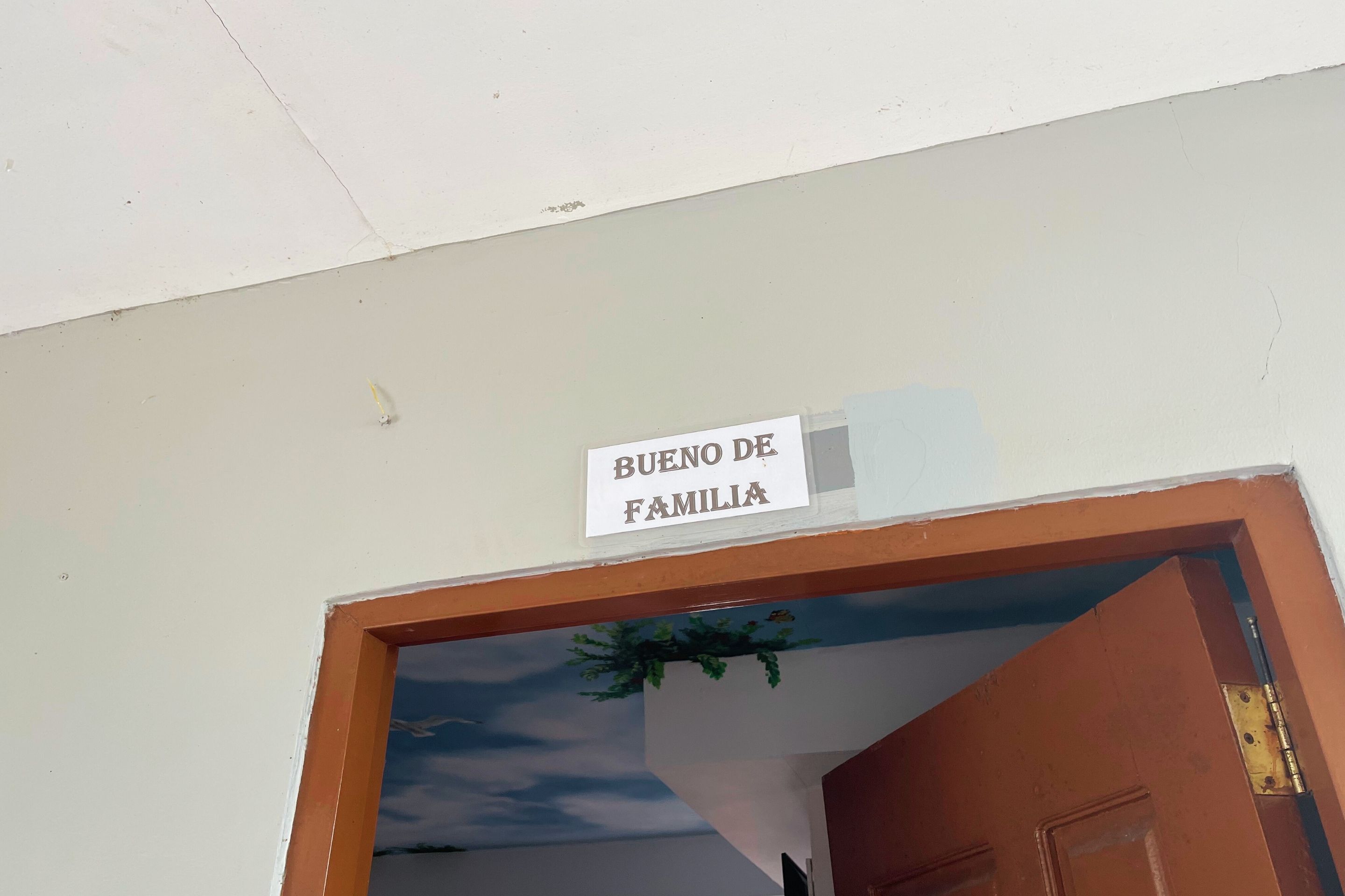A door frame with a sign that reads "BUENO DE FAMILIA".