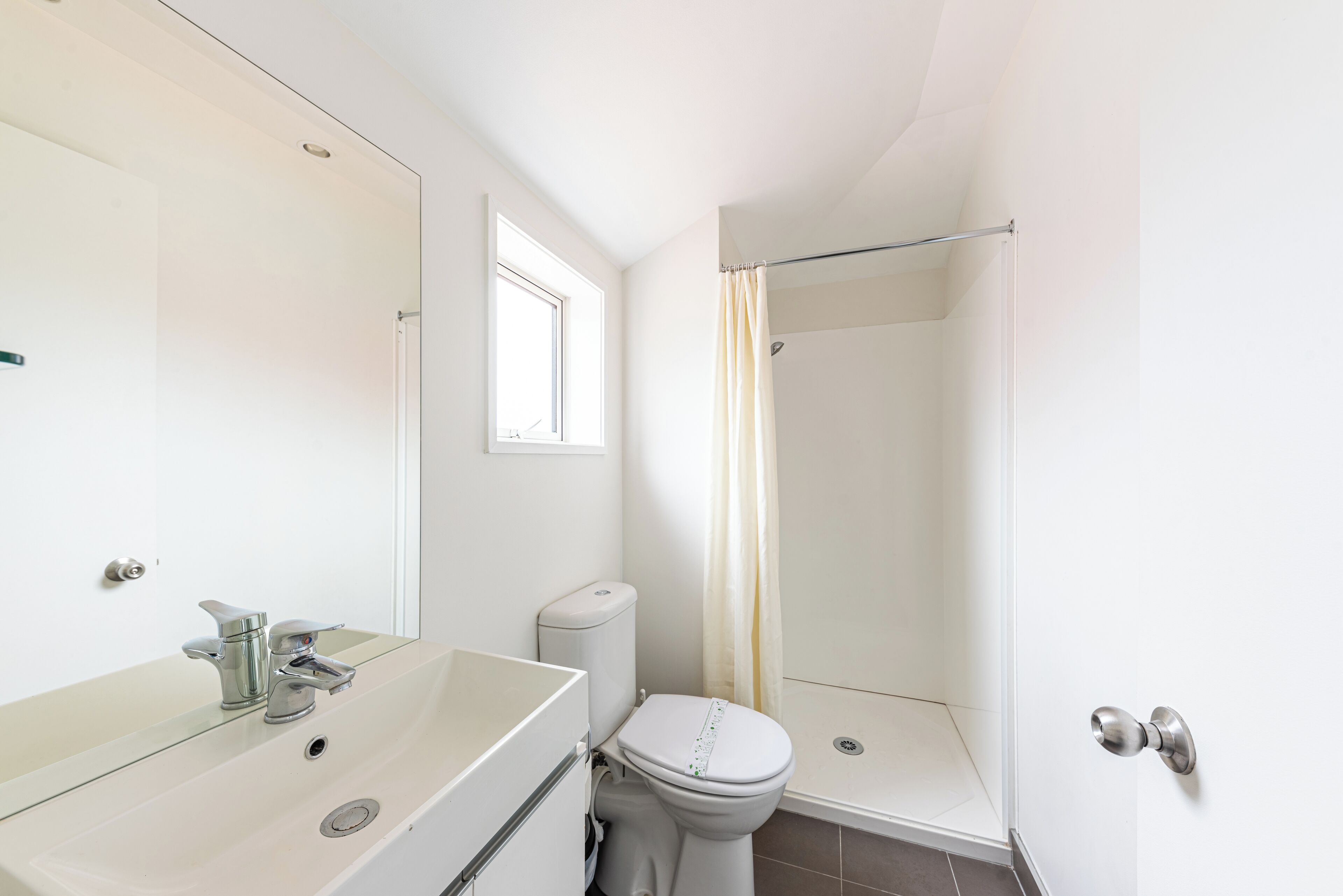 A bathroom with a sink, toilet, and shower.