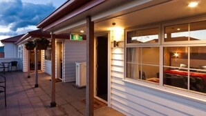 A hotel exterior with a covered outdoor area, an exit sign, and a window with a view of the interior. - 315 motel Riccarton (Christchurch)