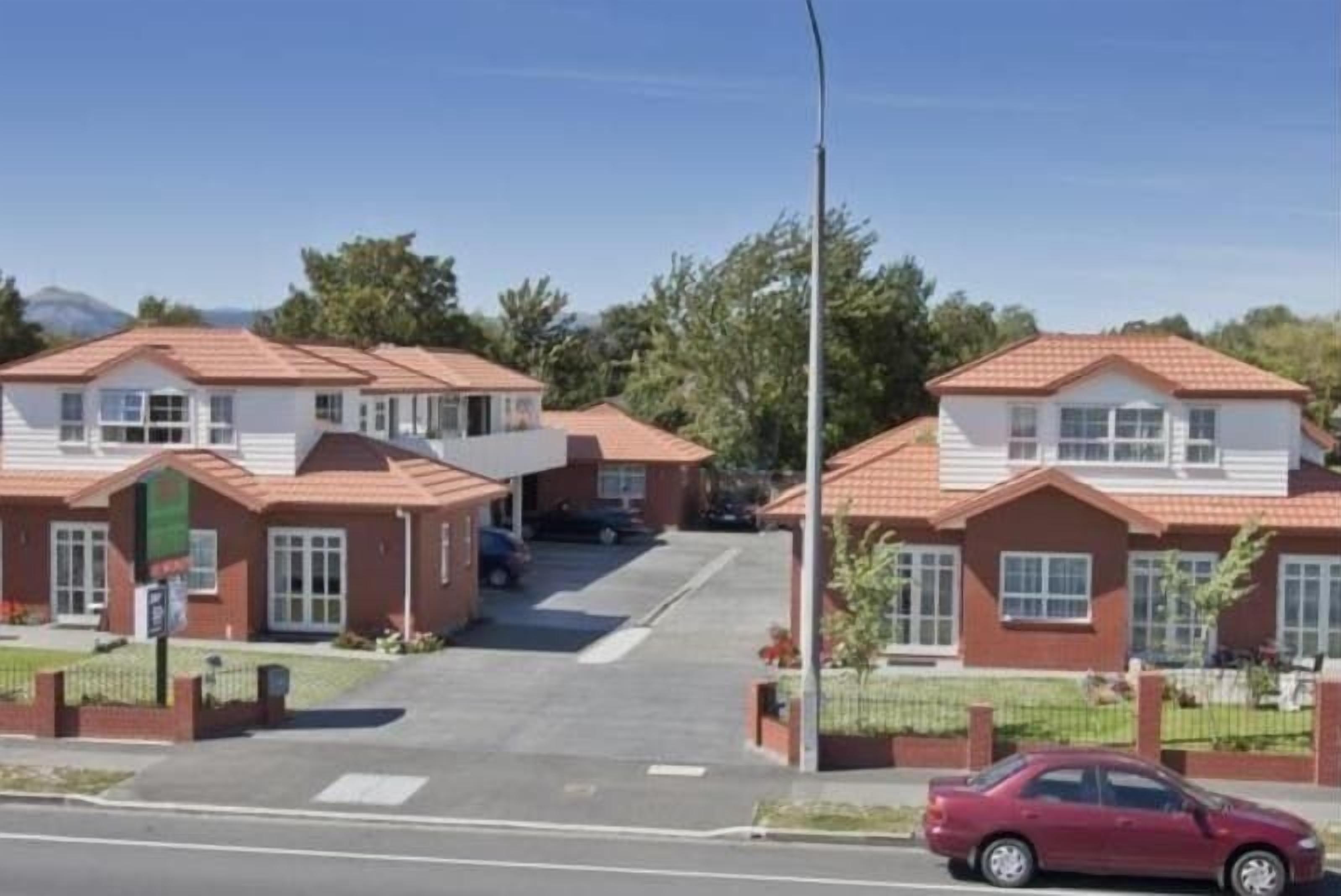 A residential area with houses featuring red-tiled roofs and white walls.
