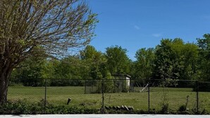 A swimming pool with a metal ladder, surrounded by a fence and trees. - 5 acre Luxury estate. 15 min from Niagara Falls (Welland)