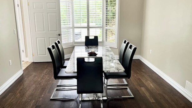 A dining room with a rectangular table, six chairs, and a window with blinds. - 5 acre Luxury estate. 15 min from Niagara Falls (Welland)
