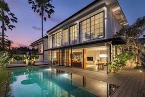 A modern two-story house with a swimming pool, large windows, and outdoor seating. - The Fernweh (Kerobokan)