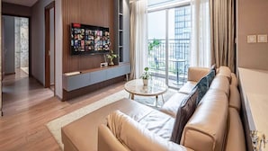 Ein modernes Wohnzimmer mit einer Ledersofa, einem runden Couchtisch und einem wandmontierten Fernseher.