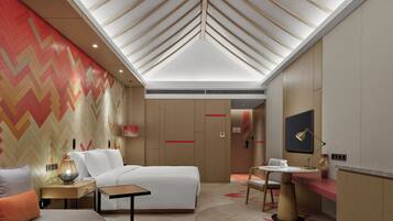 Een moderne hotelkamer met een groot bed, een bureau, een stoel en een televisie. De wand is voorzien van een patroon en het plafond heeft een uniek ontwerp.