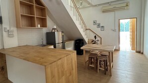 Une cuisine spacieuse dotée d’un îlot central en bois, d’une cuisinière intégrée et d’un coin repas avec une table et des chaises en bois.
