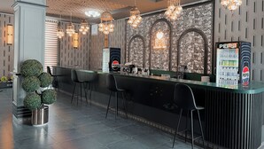 Un área de bar moderna con un fondo de pared de piedra, varias lámparas colgantes y un refrigerador de Pepsi.