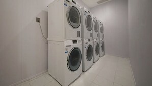 Une buanderie équipée de quatre machines à laver superposées.