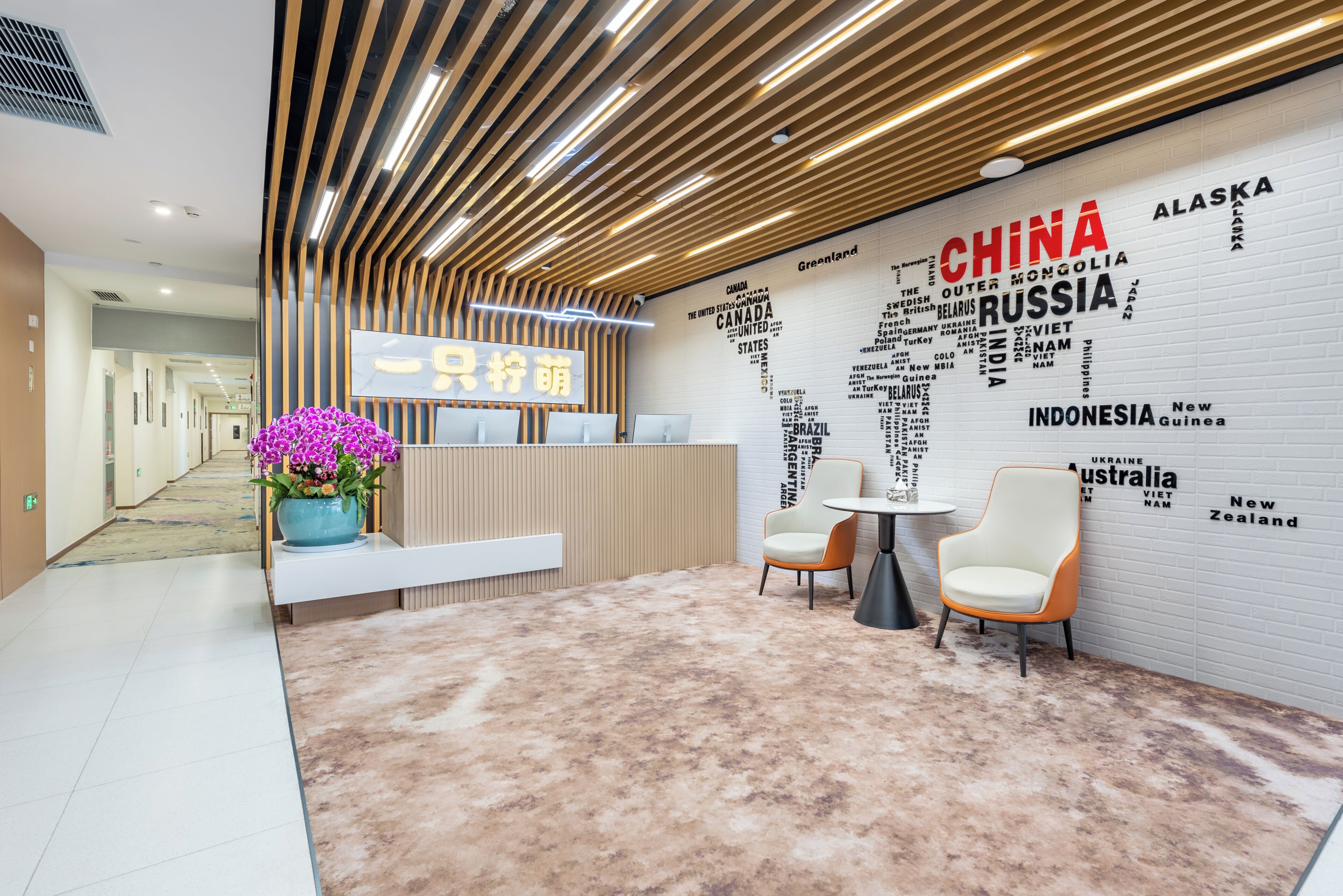 A modern reception area with a world map wall, a reception desk, and seating.