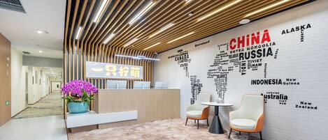A modern reception area with a world map wall, a reception desk, and seating.