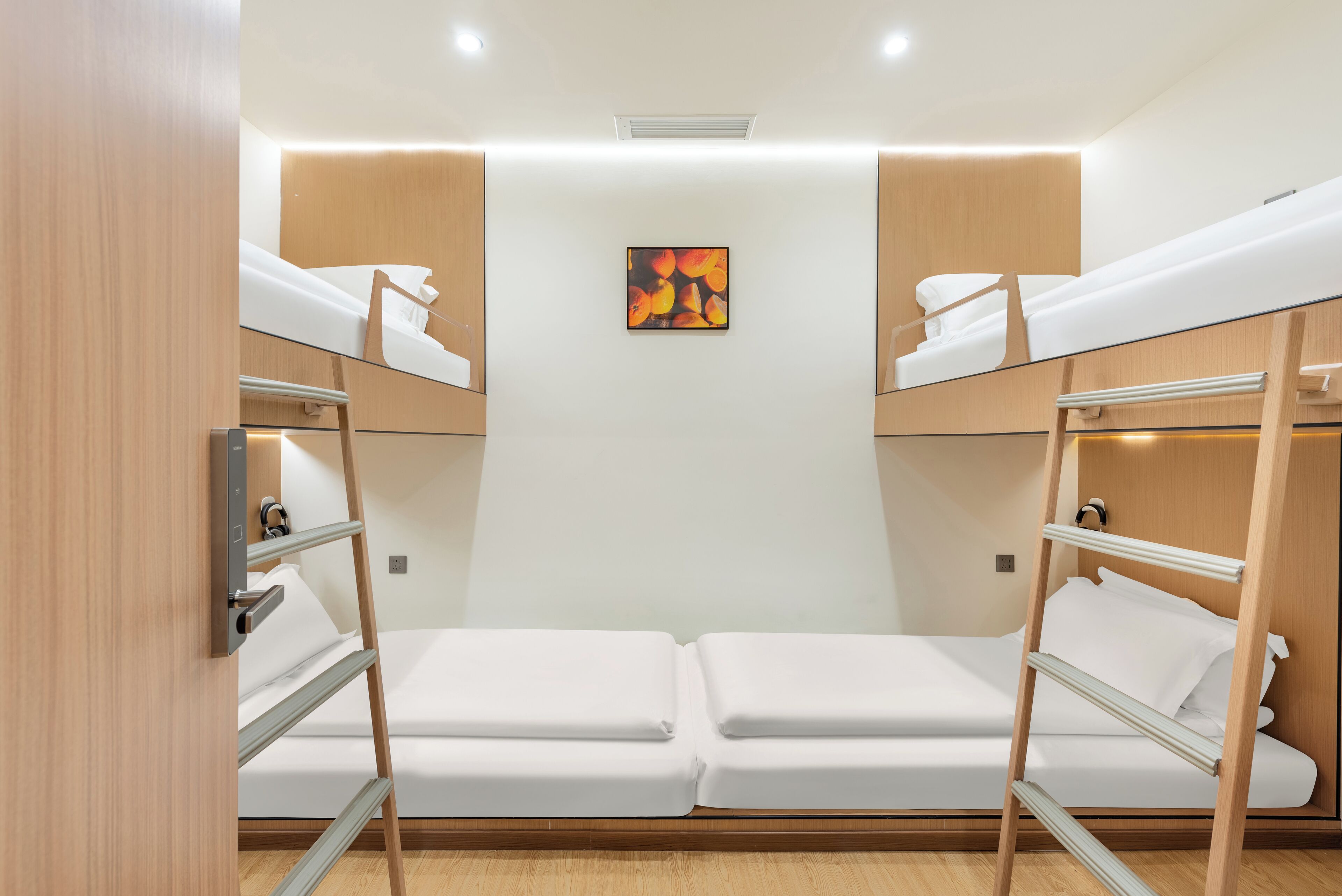 A bunk bed room with a painting on the wall, wooden furniture, and a white ceiling.