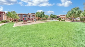 A residential complex with a playground, well-maintained lawns, and a clear blue sky. - Charming 2-bedroom condo near to Strip (Las Vegas)