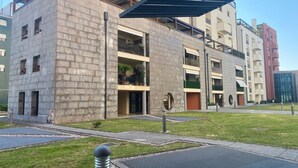 A modern building with a stone facade, multiple balconies, and a covered outdoor area. - GuestHost - Cozy 38 sqm apartment for 2 people, located near the Porta di Aquileia in Udine. It features a reserved covered parking space for guests, offering comfort and convenience. The area is rich in history and charm, just steps away from Udine's hi (Udine)