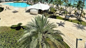 Un resort con piscina, zona de playa y palmeras.