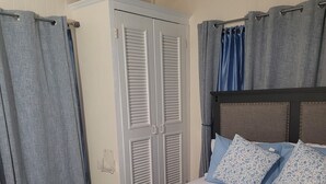 Una camera da letto con un letto, due porte e tende.