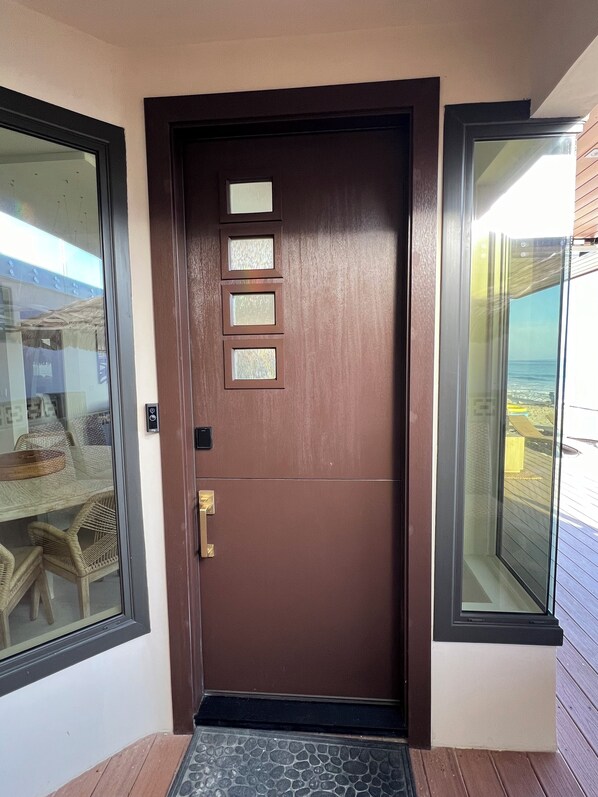 A brown door with a glass panel and a keypad lock. - Magical OceanFront home in Capistrano Beach. All the comforts of home and more! (Dana Point)