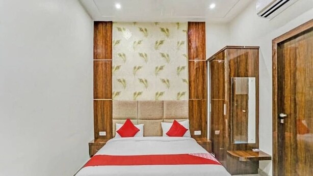 Quarto de hotel com cama grande, guarda-roupa de madeira e espelho.