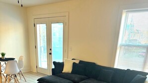 A modern living room with a sectional sofa, a small round coffee table, and a patterned rug.