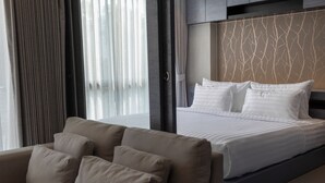 A modern hotel room with a bed, a sofa, and a view through large windows. - 600m to beach New City gate P214 c60 (Kamala)