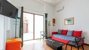 A modern living room with a sofa, chairs, a coffee table, and a television.