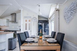 A modern kitchen with a dining area. - 2 Manor Lodge - 2 Bedroom Lodge - Pendine (Carmarthen)