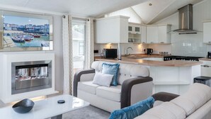 Een moderne woonkamer met een bank, een salontafel en een open haard.