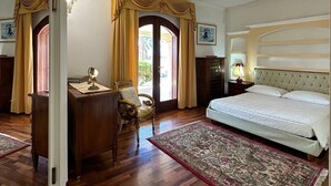 Une chambre avec un grand lit, un plancher en bois, un bureau et une chaise.