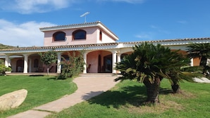 Une maison à deux étages avec un patio, une antenne parabolique et un ciel dégagé.