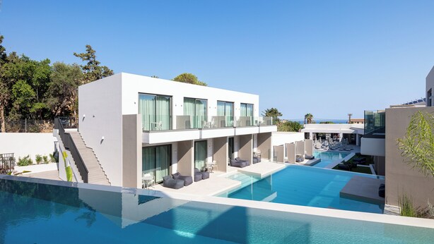 Un hôtel moderne doté d’une piscine, d’un espace extérieur aménagé et d’un escalier menant aux étages supérieurs.