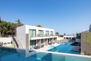 Un hotel moderno con piscina, area salotto all'aperto e una scala che conduce ai piani superiori.