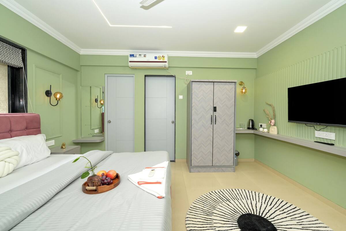 A bedroom with a bed, bedside tables, a wardrobe, a television, and a ceiling fan.
