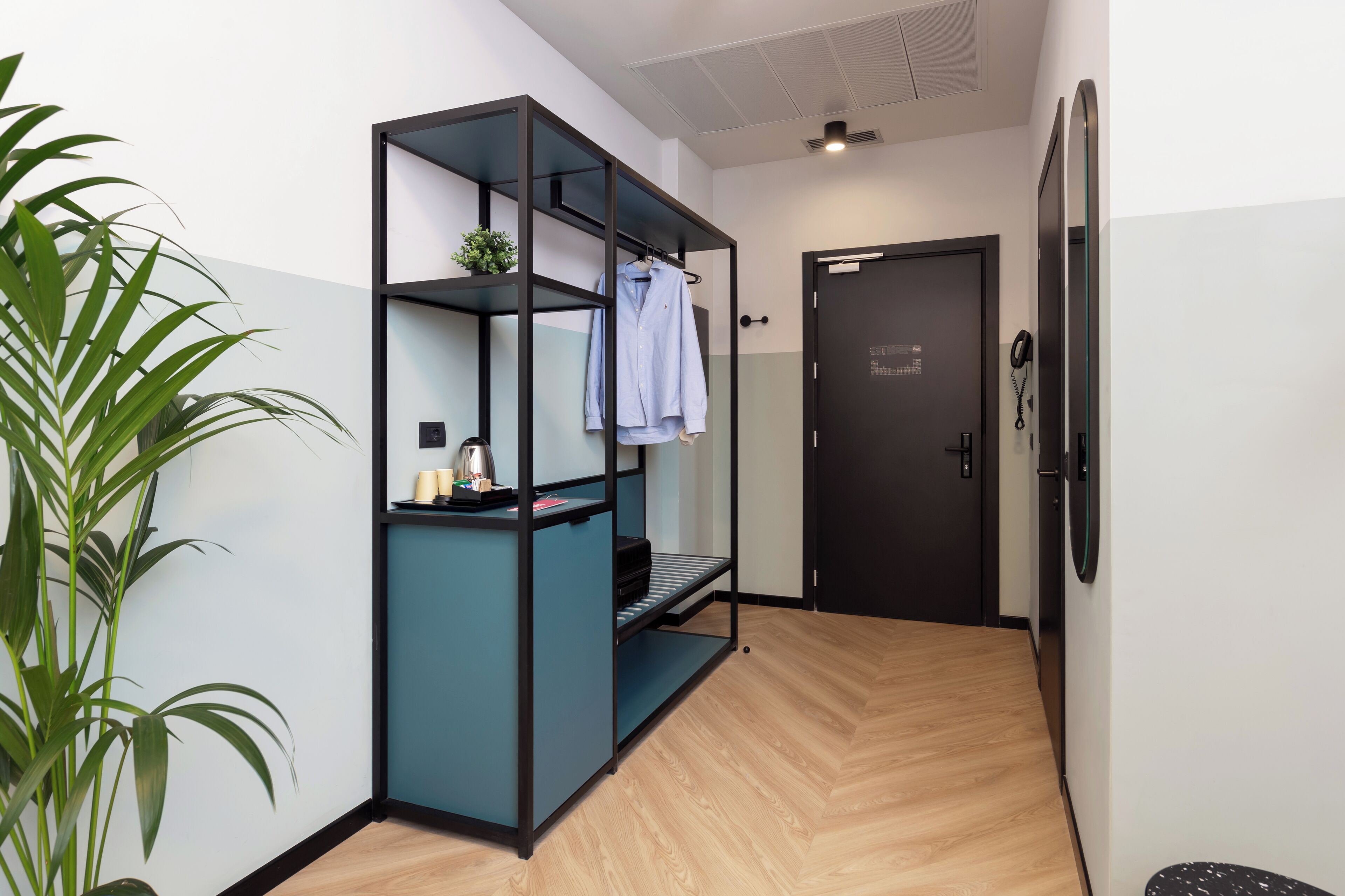 Una habitación con estantería empotrada, una puerta y una planta en maceta.