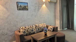 Ein Wohnzimmer mit einer Couch, einem Holztisch und einer Wandklimaanlage.
