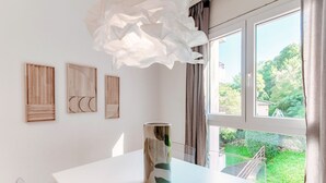 A modern room with a white table, a vase, and three wooden wall art pieces. - App. near italian border (Pink Flat 2) (Chiasso)