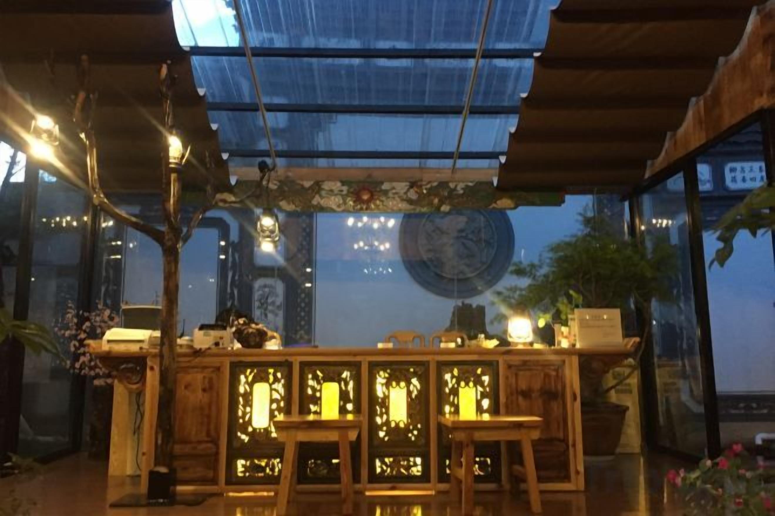A bar area with a wooden counter, hanging lights, and a large round clock on the wall.