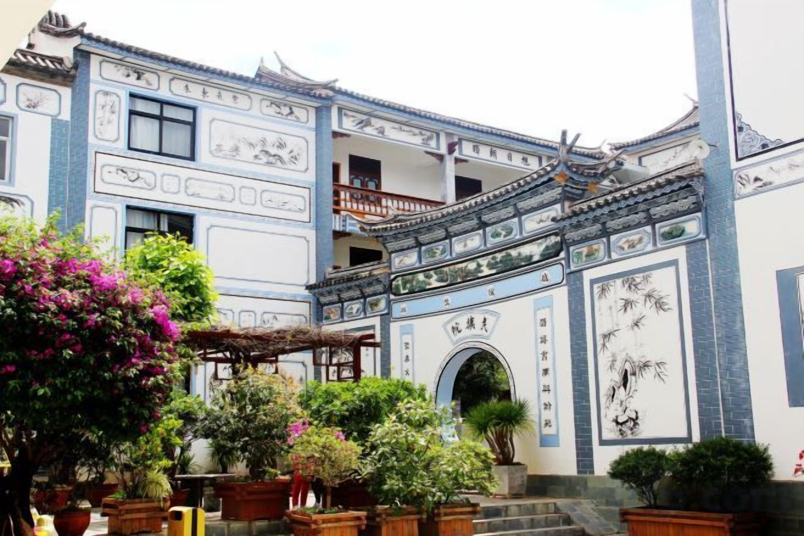 A traditional building with a tiled roof, a balcony, and a gate.