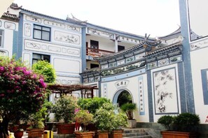 A traditional building with a tiled roof, a balcony, and a gate. - New Hotel Busan (Weishan)