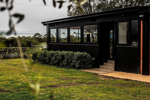A modern black building with large windows and a well-maintained lawn.