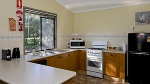 Eine Küche mit Mikrowelle, Herd, Spüle und Kühlschrank.