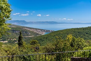 A coastal landscape with a clear view of the sea, a town in the valley below, and a forested hill. -  Casa Giuseppe (Labin)
