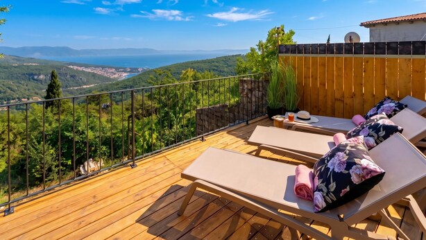 A wooden deck with lounge chairs and a view of a coastal landscape. -  Casa Giuseppe (Labin)