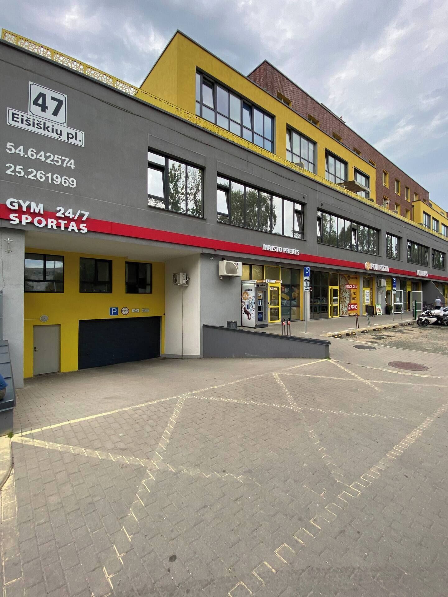 En bygning med fitnesscenter, sportsbutik og pizzeria.