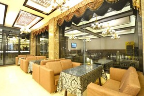 A restaurant with high ceilings, chandeliers, and a modern interior design.