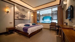 A modern hotel room with a large bed, a desk, a chair, and a large window with a view. - Meishike Express Hotel (Emeishan City)