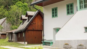 A traditional wooden building with a sloped roof, a green door, and a window with a green frame.