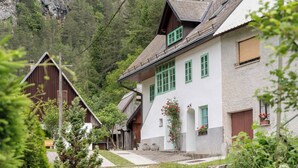 A rural mountain village with traditional wooden houses, a clear path leading to the buildings, and lush greenery. - Cosy apartment for 2 persons in mountain area (Log pod Mangrtom)