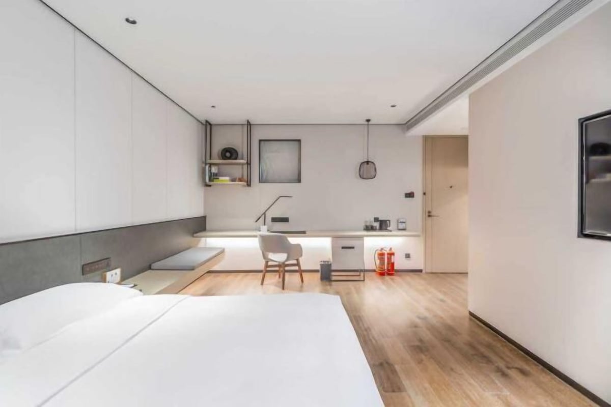 Una habitación de hotel moderna con una cama, un escritorio y una silla.