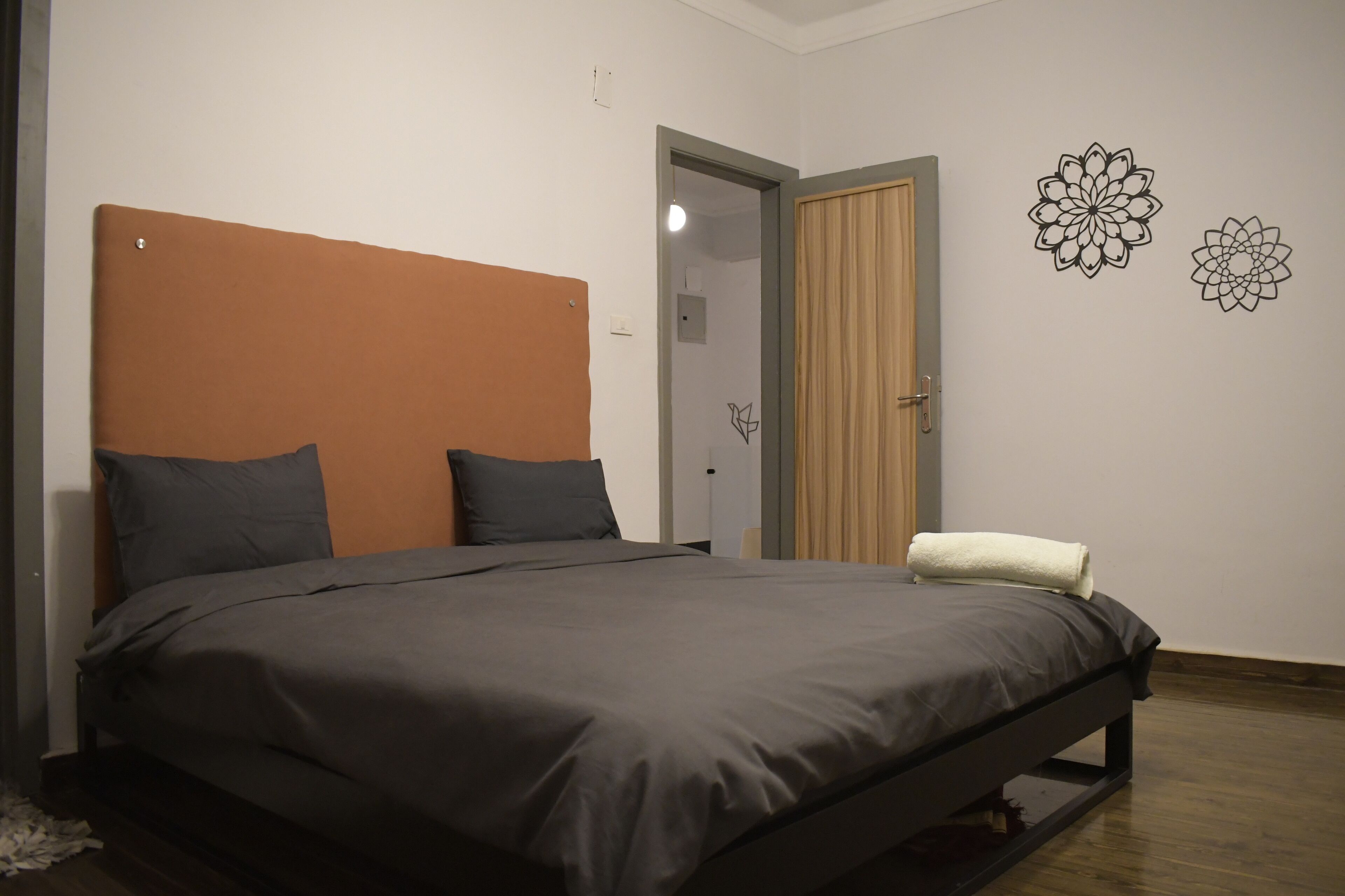 A bedroom with a bed, a chair, and a door.
