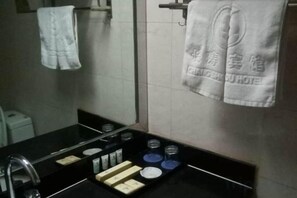 A bathroom with a black sink, mirror, and towel rack. - Changshou Business Hotel (Luntai)